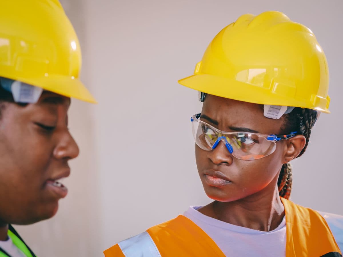 Professionnels noirs supervisant un chantier en tenue de sécurité